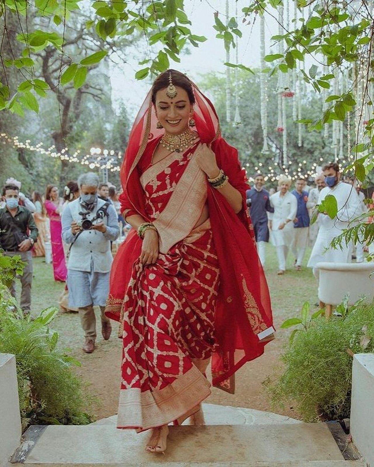 For her intimate ceremony, Dia Mirza broke convention by opting for a Benarasi red saree that made a strong sustainability statement. She completed her look with a matching gold choker, maang tikka and jhumkas, along with green and gold bangles.